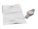 a watch sitting on top of a piece of paper next to a watch