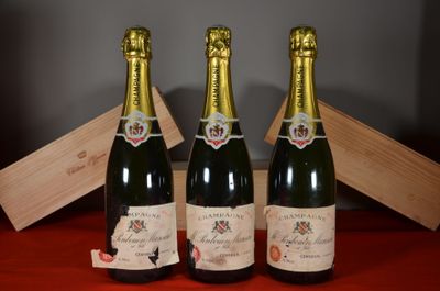 deux bouteilles de champagne posées à côté d'une caisse en bois sur une table