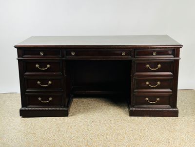 un bureau ancien en bois, doté de quatre tiroirs et d'un plateau en marbre