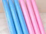 quatre bougies roses et bleues posées sur un plan de travail en marbre
