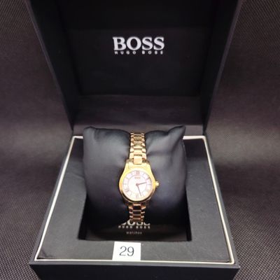montre de luxe dans un coffret noir, avec un bracelet en or et un cadran rose