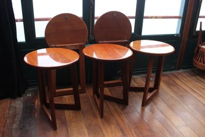 trois tabourets en bois placés les uns à côté des autres sur un plancher en bois
