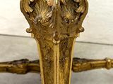 an image of a gold bench with a green cushion on it