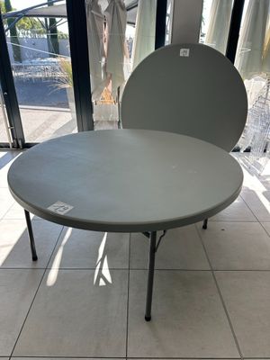 a table that has a chair on it in front of a window