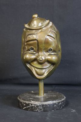 bronze statue of a smiling face with a hat on top of it