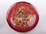 a red plate with a picture of a bird on it