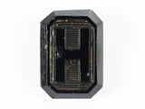 un gros plan d'un petit objet noir sur une surface blanche