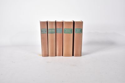trois livres superposés sur une surface blanche