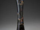 a black vase with a floral design on it