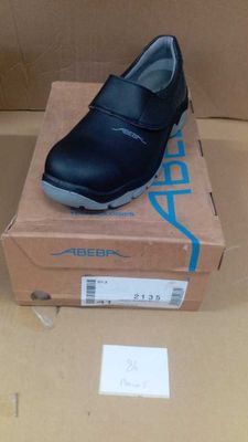 black leather school shoes in a box on top of a cardboard box