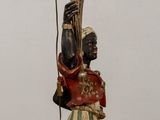 a statue of a man holding a candelier on a table