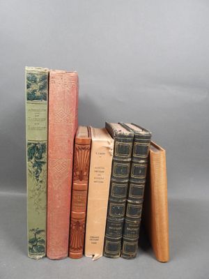 several old books are stacked on top of each other on a gray surface