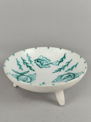 petit bol orné de motifs verts et blancs, posé sur un socle