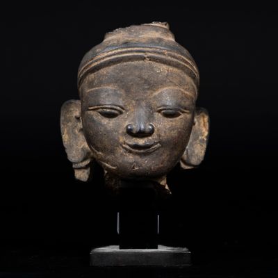 un gros plan du visage d'une femme sculpté sur une statue, sur fond noir