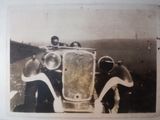 an old photo of a group of people standing next to a car