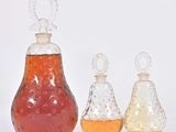 trois bouteilles de liquide posées les unes à côté des autres sur une surface blanche