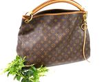 brown louis vuitton handbag with a green plant in front of it