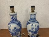 two blue and white vases on a wooden table with a white wall in the background