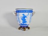 un vase bleu et blanc posé sur un socle, sur une surface blanche