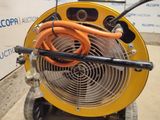 a yellow fan with a hose attached to it in front of a wall