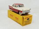 a red and white toy car sitting on top of a box