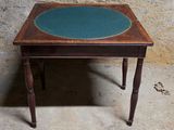 une petite table au plateau bleu posée sur un sol en béton