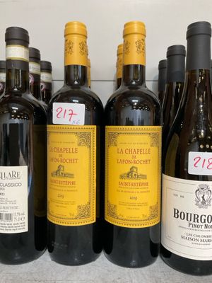 des bouteilles de vin sont alignées sur une étagère dans un magasin