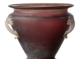 a red vase with two handles sitting on a white surface