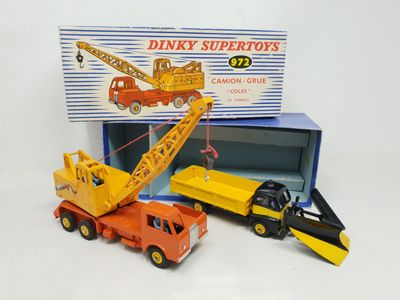 three toy trucks and a crane in a box