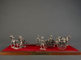 silver figurine of four horses pulling a carriage on a red carpet