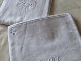 deux serviettes blanches ornées de monogrammes brodés, posées sur un lit