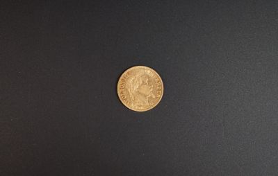 une pièce d'or posée sur une surface noire
