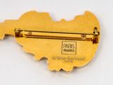 a gold pin with a map of paris on it