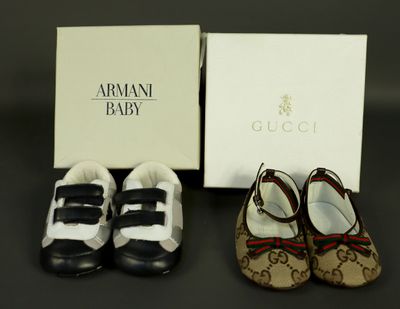 two pairs of baby shoes are sitting next to a box