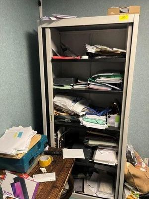 a closet full of clutter in the corner of a room