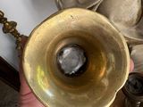 a person holding a brass object in their hand