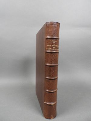 un vieux livre posé sur une table blanche devant un fond gris