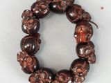 un bracelet composé de perles en bois ornées de têtes de mort