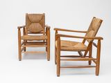 two wooden chairs with wicker seats on a white background