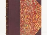 an old book with a red cover and a gold and red design