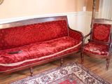 un canapé rouge et deux fauteuils dans un salon