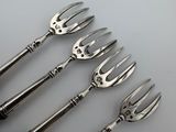 four forks are lined up on top of a white surface