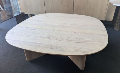 a wooden table with a wooden base in a room