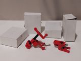 quatre engins de chantier rouges et blancs posés sur une table blanche