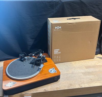 a record player sitting on a wooden table next to a box