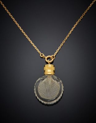 a gold plated pendant with a leaf inside of it