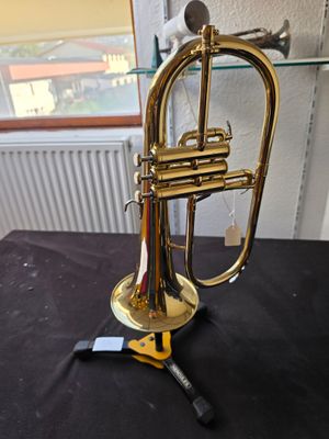 a brass trumpet sitting on a table with a black cloth