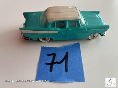 une petite voiture sur laquelle figure un numéro, à côté d'un bout de papier