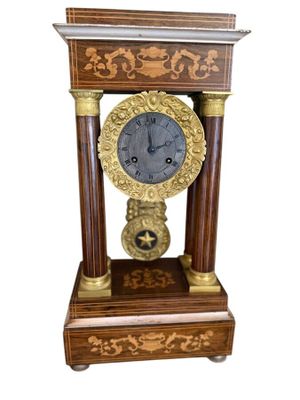 a clock that is sitting on top of a wooden stand