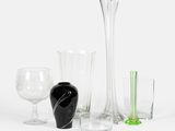 de nombreux vases et verres en verre de toutes sortes sur la table